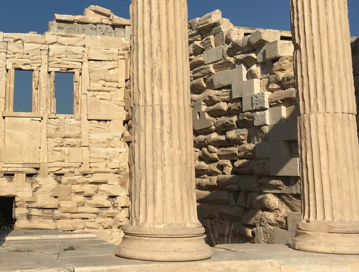 A closer view of columns that are very aged with brickwork behind where you can see centuries of erosion.